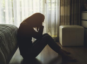 depressed woman sitting in the dark bedroom Psicólogo TCA Málaga